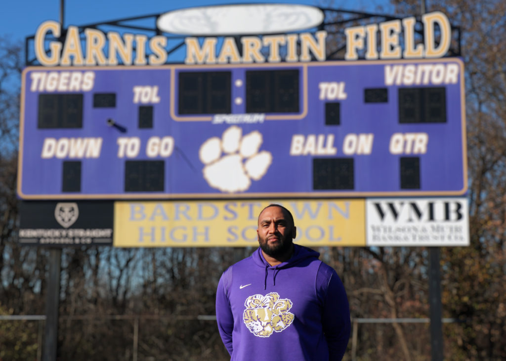 Justin Grundy stands in front of the scoreboard at Garnis Martin Field.