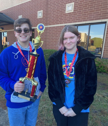 Two BMS Archery Athletes With A Medal and Trophy